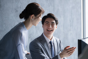 Male and female businessmen and women looking at computers at work in their offices.