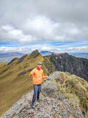 Fototapeta premium Pichincha Province, Quito, Ecuador - July 5, 2025: Tourist at the summit of Pasochoa Volcano, located in the Pasochoa Wildlife Refuge. The extinct volcano is 4,200 meters high.