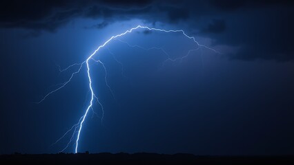 A dramatic lightning strike illuminates the dark stormy sky with electric blue brilliance.