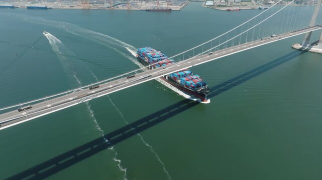 Container ship passing under the Yi Sun-sin Bridge across the sea(이순신 대교 아래를 지나는 컨테이너선)