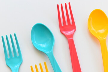 colorful spoon and fork isolated on white background, plastic cutlery for picnic