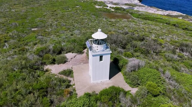 Kurnell, Sydney, Australia: Drone Video: Flying in a circle above Cape Baily Lighthouse -Higher view of the beautiful coastline of Kamay National Park with Sydney City views in the distance.