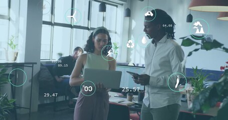 Opening laptop, woman and man analyzing sustainability data in office, animated icons updating - Powered by Adobe