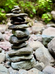 Outdoor creek feeding from the famous Kaaterskill Falls near North South Lake in Haines Falls, NY in the Catskills. Stacked grey stone rock cairn.  Tranquil wooded and water backdrop. Relax. peaceful.
