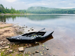Black, one person fold up, kayak that rolls for easy carry assembled along the shoreline of a beach...