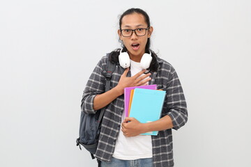 Young asian male college student wearing casual clothes, backpack, glasses, headphones around neck,...