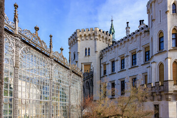 Historic european castle with ornate iron greenhouse and stone towers
