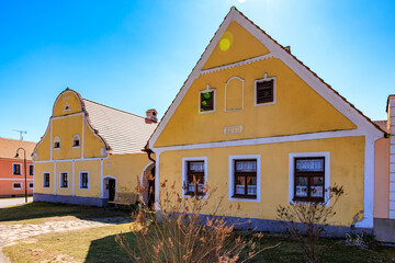 Charming czech village houses with yellow facades under clear blue sky