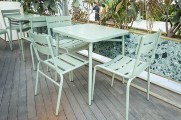 light green iron table and chairs outdoors.