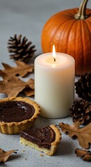 Fototapeta premium Cozy autumn scene with pumpkin tarts and candlelight