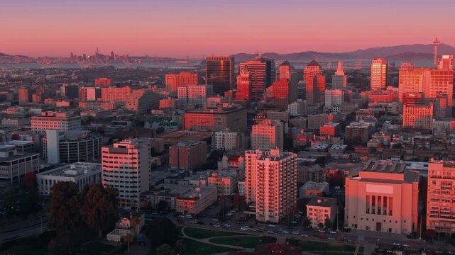 Oakland, California, USA, cityscape at sunset. The photo captures the city's skyline and Lake Merritt, showcasing the urban landscape bathed in warm light.