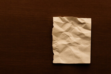Crumpled paper on wooden surface with soft lighting creating calm mood