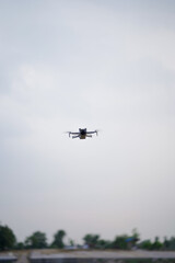 Flying drone in clear sky, Modern drone capturing footage, Aerial drone photography concept, Drone with blurred background.




