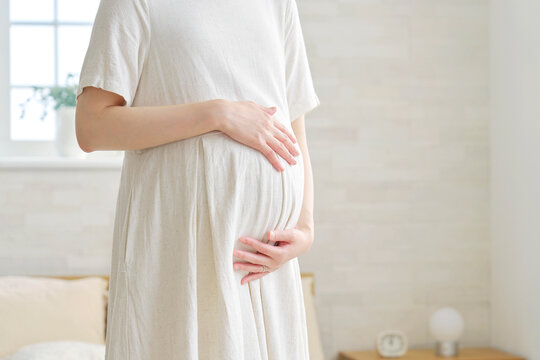 お腹を触る妊婦　顔無し　リビング