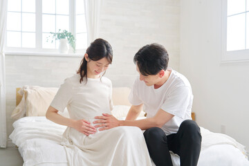 妊娠している妻のお腹を触る夫