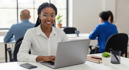 Obraz premium Photo of a smiling african american woman is working on her laptop in a modern office environment