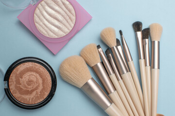 Cosmetic Brushes and Powder Collection on Pastel Surface: Makeup Essentials