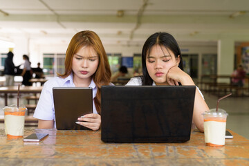 Young Thai University Students Relaxing Together at Campus Cafe Outdoors Using Technology