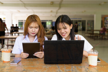 Young Thai University Students Relaxing Together at Campus Cafe Outdoors Using Technology