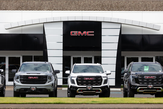 Gladstone, OR, USA - July 15, 2025 - GMC dealership in Oregon featuring multiple new GMC trucks lined up in front of the showroom with the brand&rsquo;s logo displayed on the building