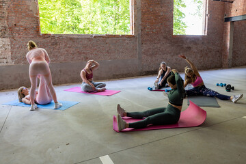 Participants enthusiastically engaged in yoga and stretching exercises within a bright and welcoming studio environment