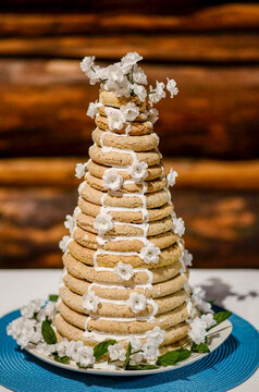 A traditional, homemade Kransekake Norwegian Wedding Cake sits on a table in a dark log cabin, ready for a special celebration.
