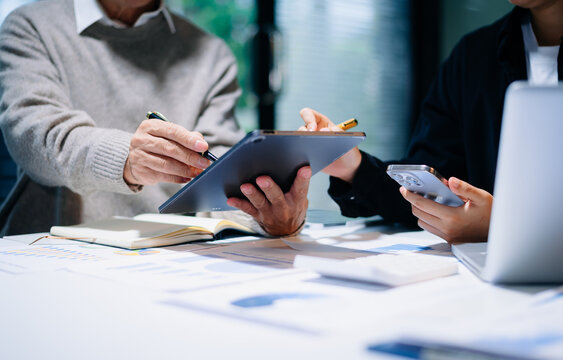 Business team collaboration discussing working analyzing with financial data and marketing growth report graph in team, presentation and digital tablet, laptop.