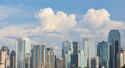 Obraz premium A high resolution image of modern skyscrapers and office towers in Jakarta central business district, Indonesia. The photo showcases glass covered buildings under a dramatic cloudy sky, representing t