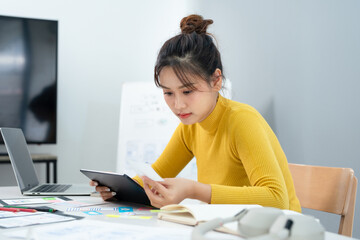 Fototapeta premium Website designer, Creative planning phone app development template layout framework wireframe design, User experience concept, Young asian UX designer working on smartphone application at office.