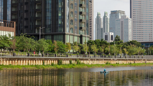 view of a public park with a lake in Jakarta in the morning with a background of modern buildings on the lake side