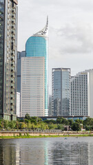 view of a public park with a lake in Jakarta in the morning with a background of modern buildings on the lake side