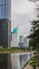 Obraz premium view of a public park with a lake in Jakarta in the morning with a background of modern buildings on the lake side