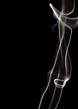 Graceful white smoke flowing against a black background in a vertical video format, ideal for abstract effects, transitions, or content related to cigarette smoke