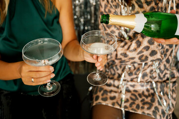 Women pouring sparkling wine into a glass during a party