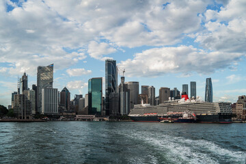 Naklejka premium Sydney, Australia - 25 January 2025 : Circular Quay ferry wharf with cruise ship view from a boat