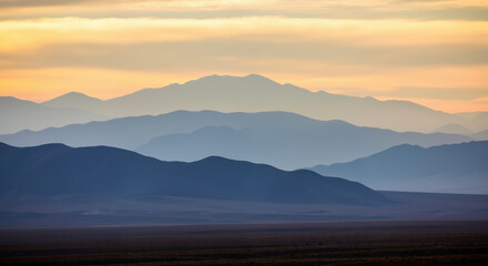 Fototapeta premium Mountain landscape with layered ridges fading into distance at sunset. Natural terrain with atmospheric perspective for environmental conservation and landscape awareness campaigns
