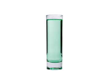 a glass filled with green liquid on a white surface