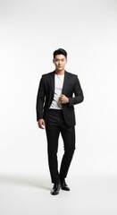 Stylish Young Korean Man in Black Suit and White T-Shirt Posing, standing in a minimalist studio with a clean white background.

