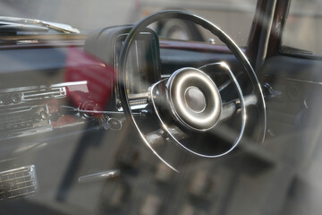 Vintage Classic car steering wheel, with chrome and leather textures in sharp detail, showcases the...