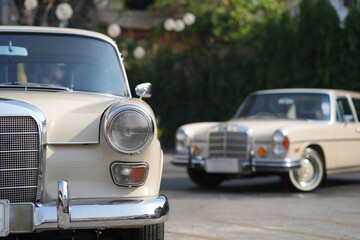 The round headlights and side turn signals on classic cars, framed in polished chrome, highlight the vintage style with old-fashioned lighting and curved fender details.