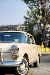 Naklejka premium The round headlights and side turn signals on classic cars, framed in polished chrome, highlight the vintage style with old-fashioned lighting and curved fender details.