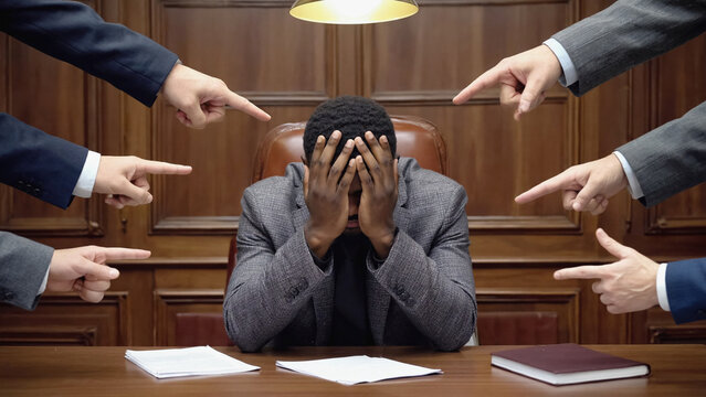 Blame Game: A striking visual of a person overwhelmed by accusatory fingers, set against a backdrop of imposing authority, suggesting the pressures of judgment and the weight of responsibility.