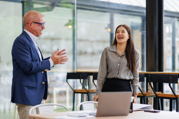 Two business people reading papers together in modern office 