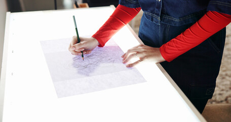 Woman, hands and sketching with light table for fashion design, art or tracing in home studio....