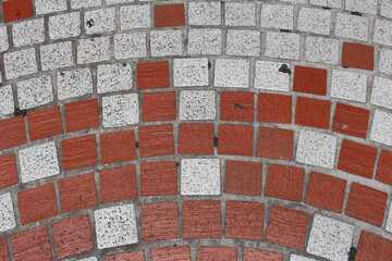 Texture of cobblestone. Pattern of sidewalk tiles in the street. Cobblestones close up. Red and gray pavement background.	
