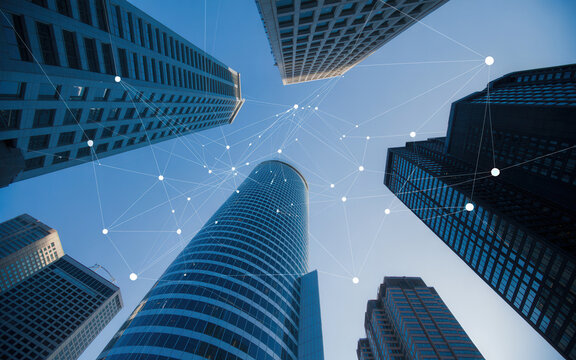Modern skyscrapers with digital network overlay against blue sky