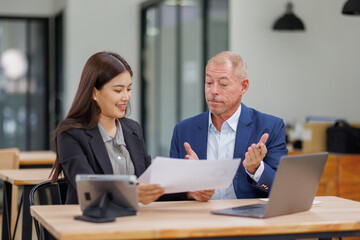 Group of confident business people point to graphs and charts to analyze market data, balance sheet, account, net profit to plan new sales strategies to increase production capacity.	