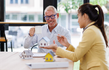 Real estate agent have a meeting with customer. sale purchase property with house model & signing contract document.mortgage loan Real Estate Agent talk with client. 