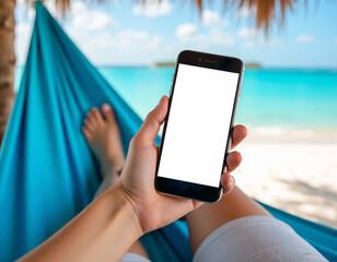 Relaxing beach vacation: A person's hand holds a smartphone with a blank screen while lounging in a blue hammock.