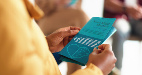 Hands, person and reading brochure in therapy for mental health info, treatment options or about us. Psychology, patient and leaflet in counseling for support resources, education or stigma reduction